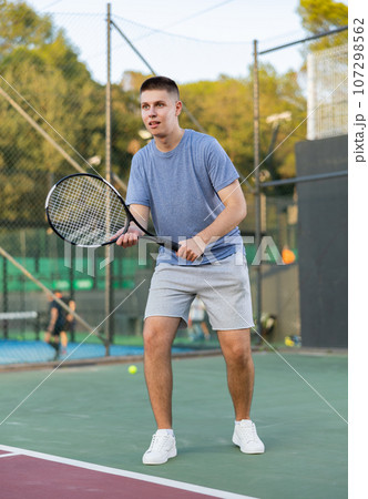 Boy tennis player training on court 107298562