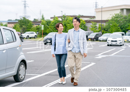 駐車場を歩くカップル 107300485