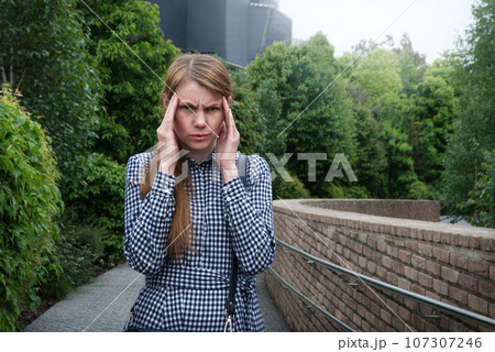Girl with a headache on the street Girl with a headache on the street 107307246