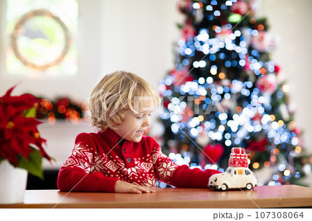 Child with Christmas present. Kid with Xmas gift. Child with Christmas present. Kid with Xmas gift. 107308064
