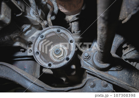 The driveshaft flange under the bottom of the car. Automotive background of transmission repair and driveshaft restoration 107308398
