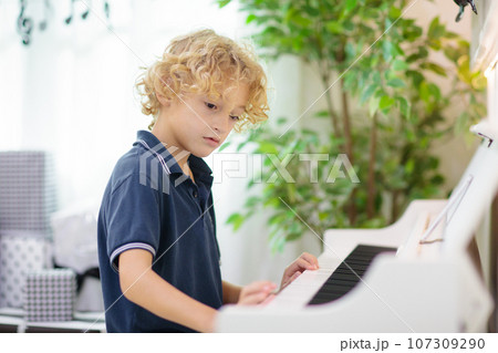 Child playing piano. Kids play music. 107309290