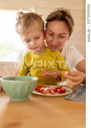 little Caucasian blond son and mother having breakfast with delicious food 107309568