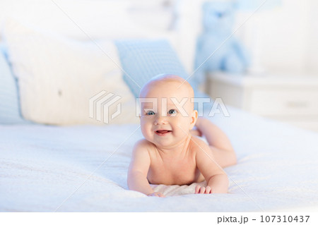 Baby boy on white bed Baby boy on white bed 107310437