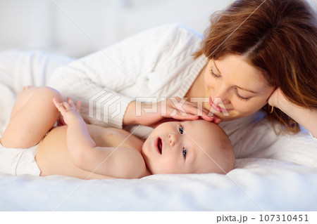 Mother and baby on a white bed 107310451