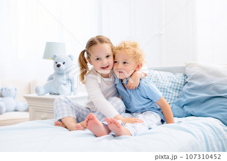 Kids playing in white bedroom Kids playing in white bedroom 107310452