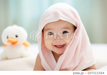 Happy Asian little baby wearing hooded towel sitting on the bed after bath, Generative Ai 107311564