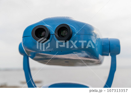 Metal stationary outdoor binoculars on the observation deck overlooking the sea. Metal stationary outdoor binoculars on the observation deck overlooking the sea. 107313357