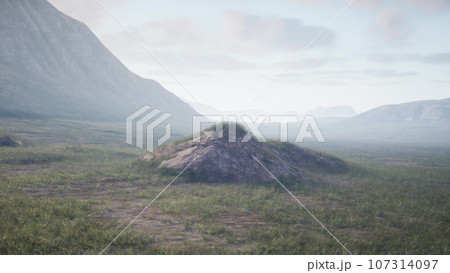 A scenic landscape with a small mound and majestic mountains in the background A scenic landscape with a small mound and majestic mountains in the background 107314097