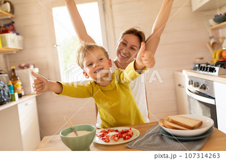 lifestyle concept, young mother and son spending time together at breakfast 107314263