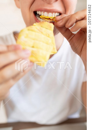 young woman taking a bite of homemade fast food 107314682