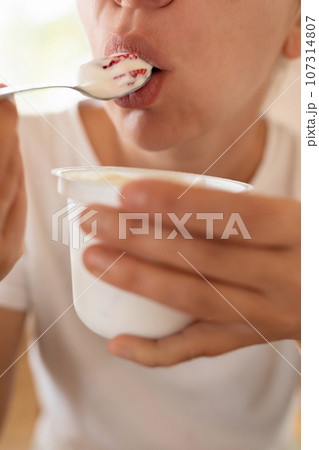 woman eats yogurt with a spoon. healthy eating 107314807