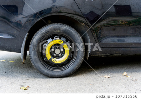 a black passenger car with a spare wheel installed is parked on the road a black passenger car with a spare wheel installed is parked on the road 107315556