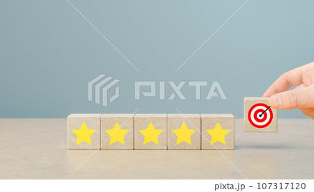 customer hand put wooden blocks with target and five yellow star symbol. Improve rating, increase ranking, improve customer satisfaction concept 107317120