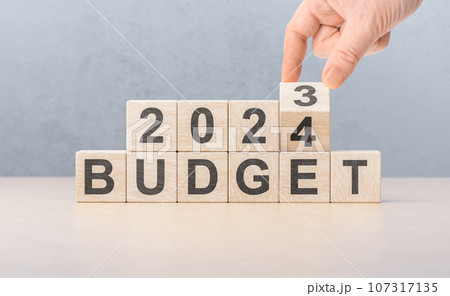 Budget 2024. hand flips wooden cube and changes words BUDGET 2023 to BUDGET 2024. New year 2024. Economy and business. 107317135