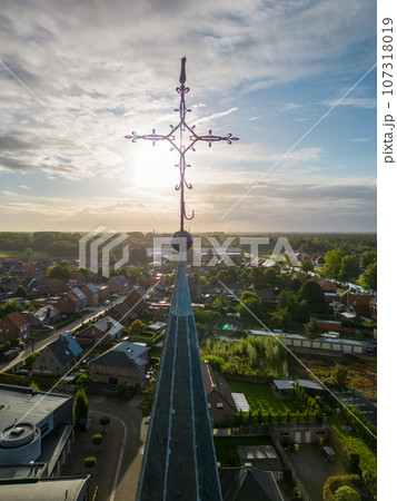 Heavenly Dawn: Church Cross Bathed in Sunrise Glow Heavenly Dawn: Church Cross Bathed in Sunrise Glow 107318019