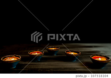 Happy Diwali - Clay Diya lamps lit during Dipavali, Hindu festival of lights celebration. 107318104