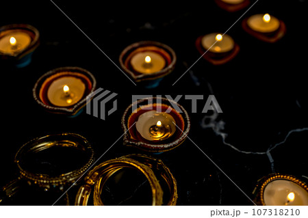 Happy Diwali - Clay Diya lamps lit during Dipavali, Hindu festival of lights celebration. Happy Diwali - Clay Diya lamps lit during Dipavali, Hindu festival of lights celebration. 107318210