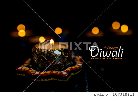 Happy Diwali - Clay Diya lamps lit during Dipavali, Hindu festival of lights celebration. Happy Diwali - Clay Diya lamps lit during Dipavali, Hindu festival of lights celebration. 107318211
