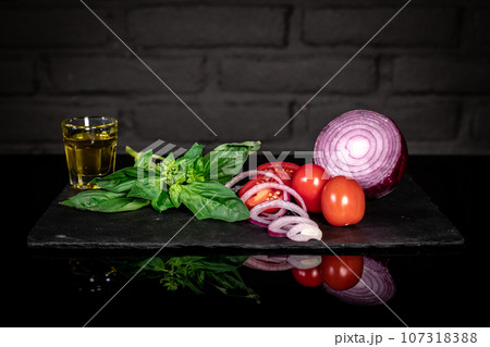 Composition of fresh tomatoes, onion, basil, olive oil, dark background Composition of fresh tomatoes, onion, basil, olive oil, dark background 107318388