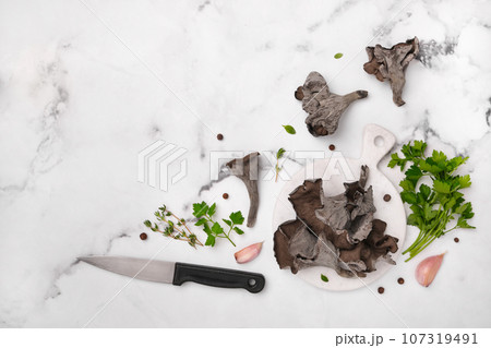 Black chanterelle mushrooms ready for cooking. Craterellus cornucopioides, or horn of plenty trumpet or of the dead Black chanterelle mushrooms ready for cooking. Craterellus cornucopioides, or horn of plenty trumpet or of the dead 107319491