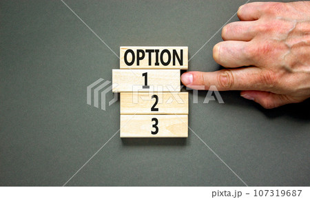 Time to option 1 symbol. Concept word Option 1 2 3 on wooden block. Businessman hand. Beautiful grey table grey background. Business planning and time to option 1 concept. Copy space. 107319687