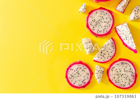 Slices of fresh white pitaya or dragon fruit on yellow background, flat lay 107319861