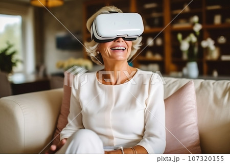 Senior mature female having fun with virtual reality glasses. Old woman using new headset goggles trends technology 107320155