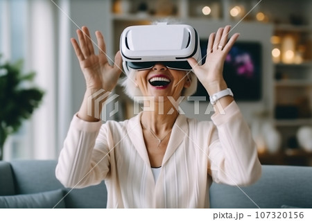 Senior mature female having fun with virtual reality glasses. Old woman using new headset goggles trends technology Senior mature female having fun with virtual reality glasses. Old woman using new headset goggles trends technology 107320156