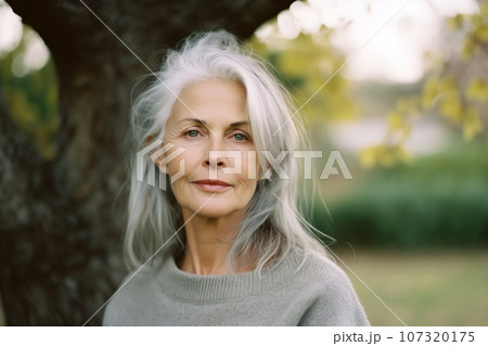 Smiling middle age grey-haired woman in outside. Autumn 107320175