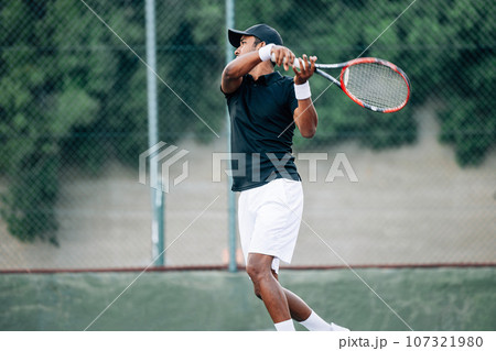 Side view of a professional tennis player returning the serve Side view of a professional tennis player returning the serve 107321980