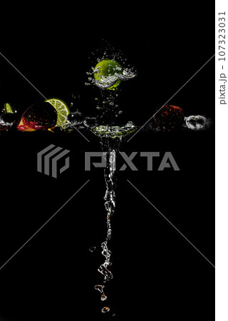 bright juicy fruits with splashes on black background. 107323031