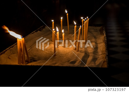 Burning church candles gilded candlestick temple dark Burning church candles gilded candlestick temple dark 107323197