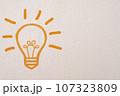 Abstract orange thinking light bulb on concrete wall background 107323809