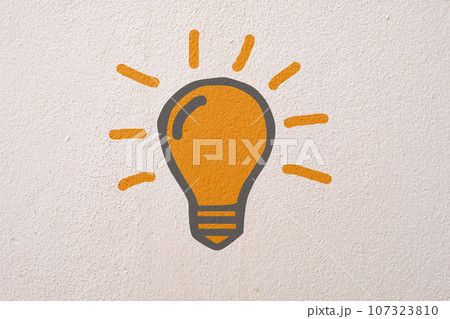 Abstract orange thinking light bulb on concrete wall background 107323810