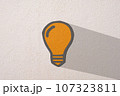 Abstract orange thinking light bulb on concrete wall background 107323811