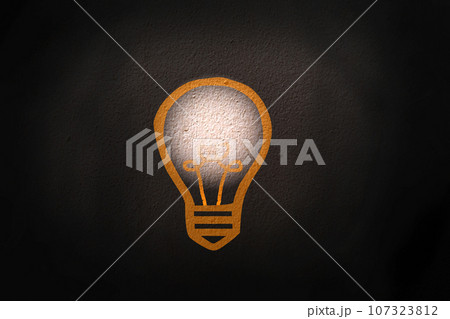 Abstract thinking light bulb on black concrete wall background 107323812