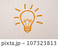 Abstract orange thinking light bulb on concrete wall background 107323813