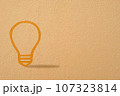 Abstract orange thinking light bulb on concrete wall background 107323814