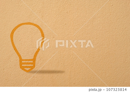 Abstract orange thinking light bulb on concrete wall background 107323814