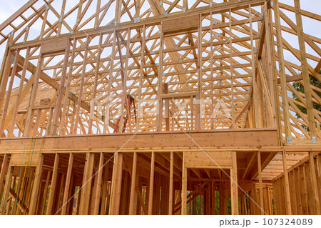 Construction work in progress an unfinished house with wooden framing beams view 107324089
