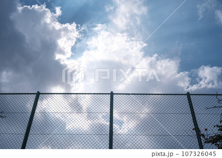 フェンス越しの空 ドラマチックな空 公園 イメージ フェンス越しの空 ドラマチックな空 公園 イメージ 107326045