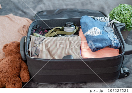 arrangement of clothes and accessories in a suitcase,Travel concept. arrangement of clothes and accessories in a suitcase,Travel concept. 107327521