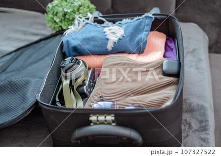 arrangement of clothes and accessories in a suitcase,Travel concept. arrangement of clothes and accessories in a suitcase,Travel concept. 107327522
