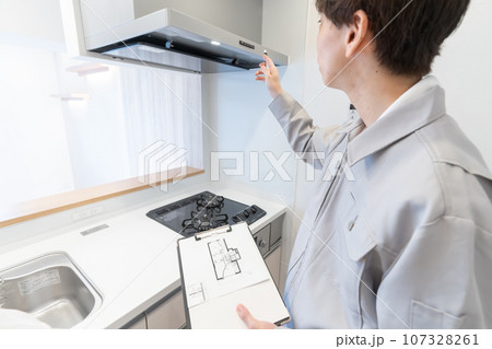 図面を見ながらキッチンのリフォームを打ち合わせする作業服の男性 図面を見ながらキッチンのリフォームを打ち合わせする作業服の男性 107328261