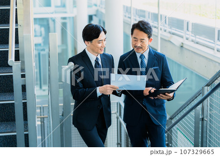資料を見ながら話をする上司の男性 資料を見ながら話をする上司の男性 107329665