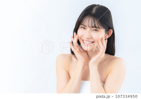 白バックでスキンケアをするミドルの女性 107334950