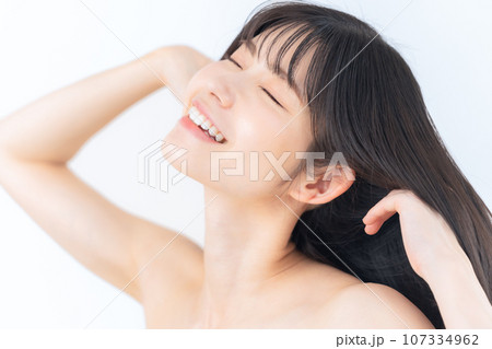 白バックでスキンケアをするミドルの女性 107334962