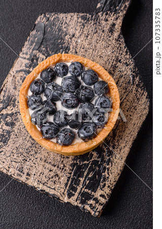 Delicious fresh sweet round tart with ripe blueberries and cream Delicious fresh sweet round tart with ripe blueberries and cream 107335783