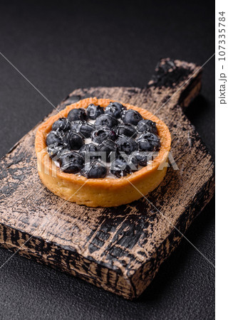 Delicious fresh sweet round tart with ripe blueberries and cream Delicious fresh sweet round tart with ripe blueberries and cream 107335784